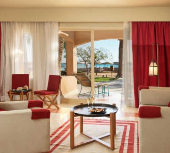 The living area of Junior Suite at Labranda Club Paradisio with a wide ceiling-to-floor glass window connected to the terrace with Red Sea view