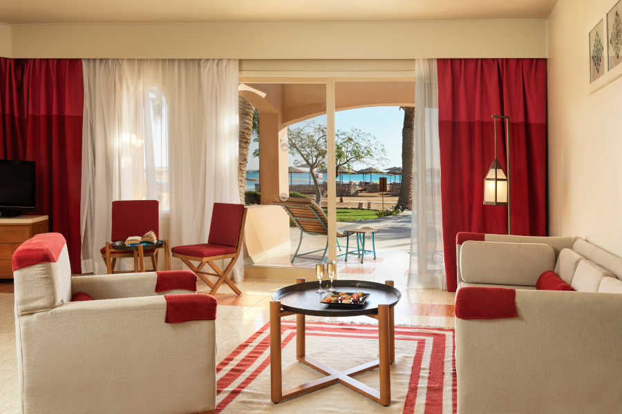 The living area of Junior Suite at Labranda Club Paradisio with a wide ceiling-to-floor glass window connected to the terrace with Red Sea view