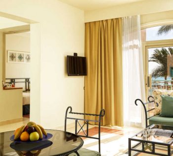 The dining table of the suite at Club Paradisio Hotel connected to the sitting area and a glass window with Red Sea view in El Gouna