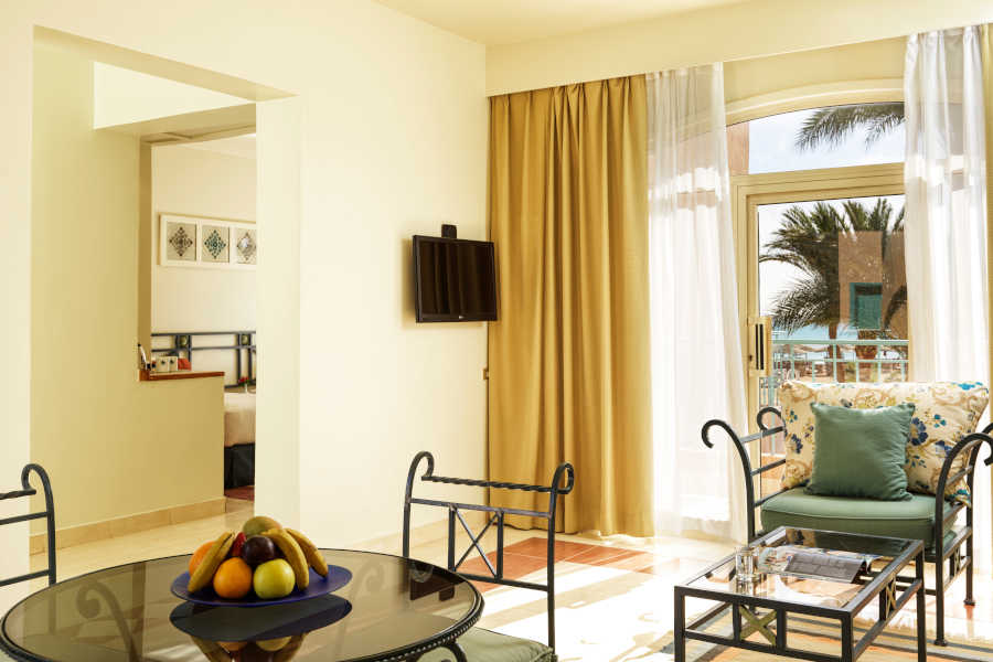 The dining table of the suite at Club Paradisio Hotel connected to the sitting area and a glass window with Red Sea view in El Gouna