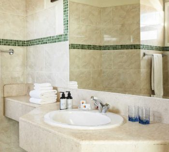 The marbled bathroom with a wide mirror, toiletries and towels