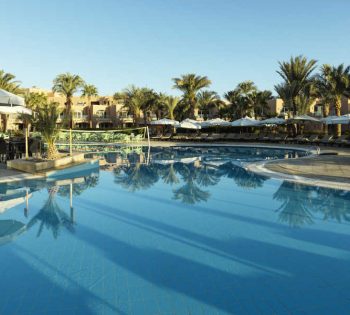 The swimming pool of Labranda Club Paradisio Hotel in El Gouna surrounded with laid back sun beds and umbrellas and a pool bar