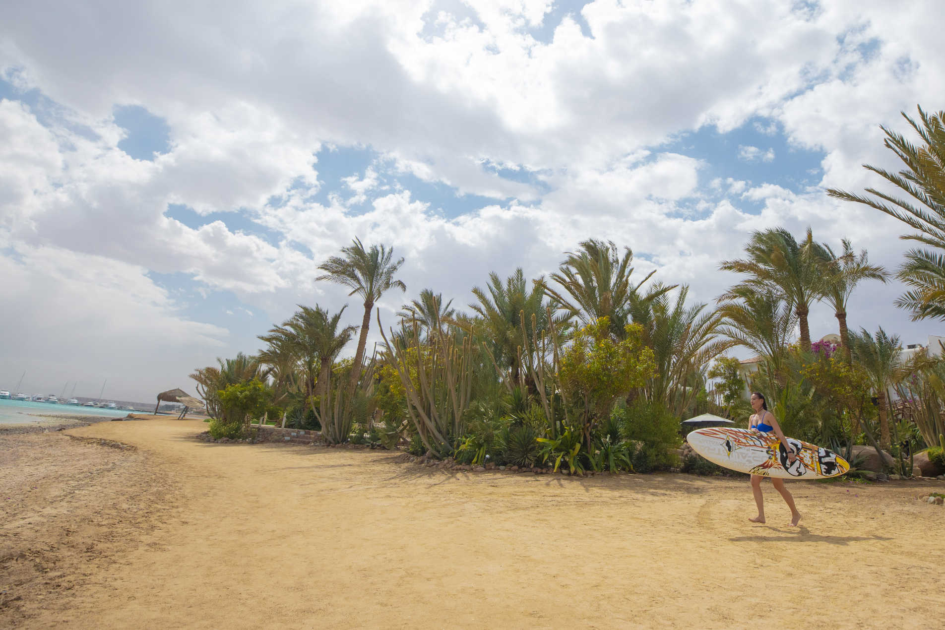 A lady is running holding kite surfing bar at Labranda Club Paradisio Hotel in El Gouna sandy beach