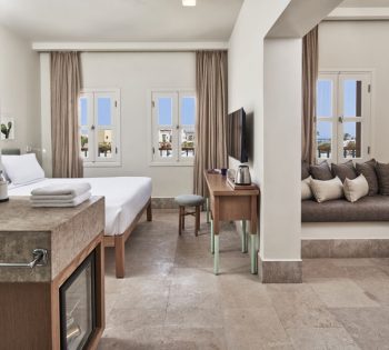 Captain's Inn Junior Suite with King size bed, marina view windows, dressing table, flat TV, screen, kettle & seating Sofa