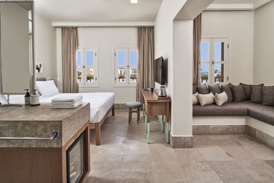 Captain's Inn Junior Suite with King size bed, marina view windows, dressing table, flat TV, screen, kettle & seating Sofa