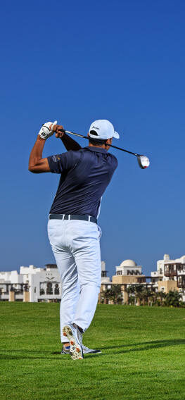 Golf Player in El Gouna golf in front of Ancient sands hotel