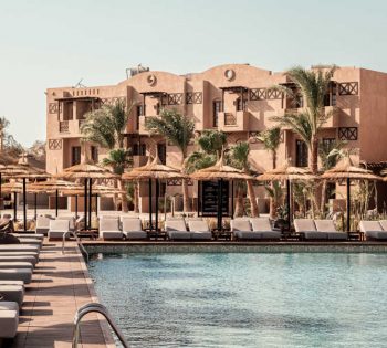 The pool view of Cook's Club in El Gouna with surrounded sunbeds