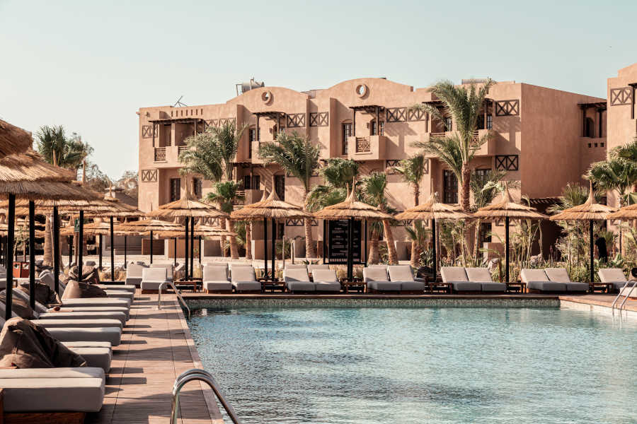 The pool view of Cook's Club in El Gouna with surrounded sunbeds