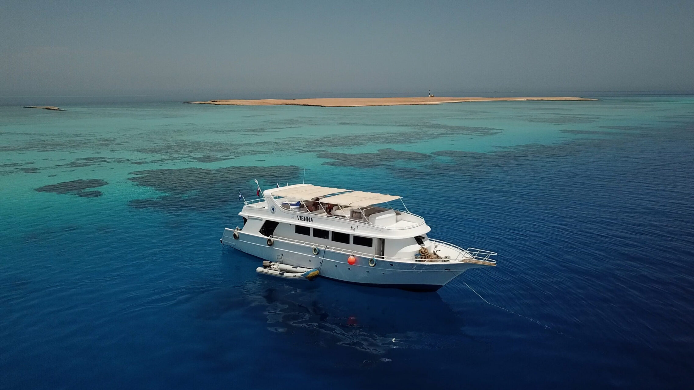 diving boat with tender on red sea reef near island