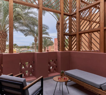 earthy tone balcony with long chair and chair overview palm trees garden in steigenberger hotel