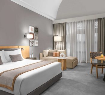 renovated room steigenberger with grey and golden modern textile, large bed and sofa