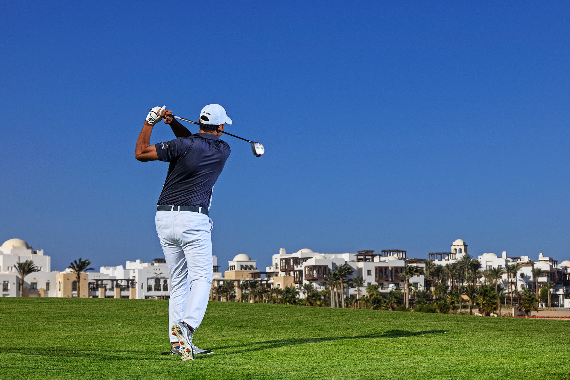 a man playing golf in a golf course.