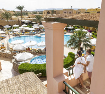 a couple enjoying the view of the pools at three corners Rihana