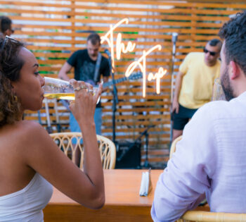 a man and a woman drinking beer, watching music perfomance at the tap
