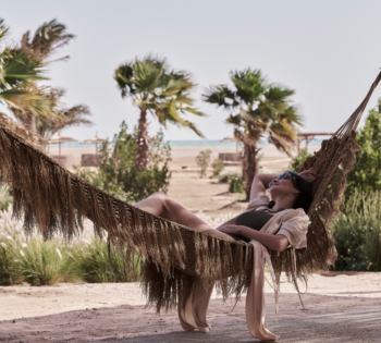 Woman lying in a hammock out in serene nature settings